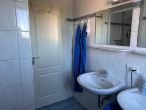 a white bathroom with a sink and a mirror at Ferienwohnung Marina am Ryck in Greifswald