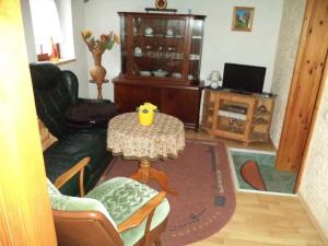 a living room with a table and a tv at Ferienwohnungen Familie Daehn in Wieck