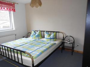 - une chambre avec un lit doté d'oreillers bleus et d'une fenêtre dans l'établissement Ferienwohnungen Ute Simdorn, à Görke