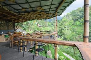 a restaurant with wooden tables and chairs on a deck at Yeh Baat Jatiluwih by The Lavana in Jatiluwih
