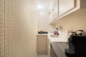 a small kitchen with a white tiled wall at Bang in Kolonaki by Athenian Homes in Athens