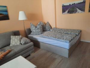 ein kleines Zimmer mit einem Bett und einem Sofa in der Unterkunft Peene Alte Schule Völschow Dornberger 