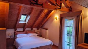a bedroom with a white bed and a window at Charme Hotel Villa Bonomo in Asiago