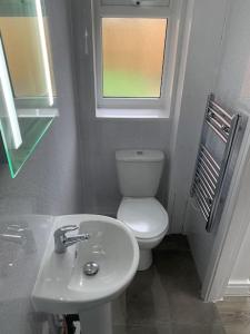 La salle de bains est pourvue de toilettes, d'un lavabo et d'une fenêtre. dans l'établissement Town Centre Getaway, à Southport