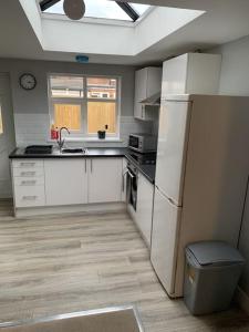 a kitchen with a white refrigerator and a window at Town Centre Getaway in Southport