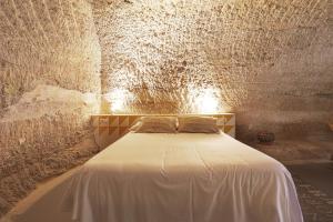 een slaapkamer met een groot bed in een stenen kamer bij Cuevas de las Bardenas in Valtierra
