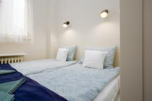 1 dormitorio con 2 camas y almohadas azules y blancas en Golden Hour Apartment, en Budapest