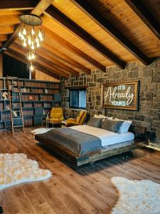 Çathan Art Hotel في آيدر يايلاسِه: غرفة نوم بسرير كبير وجدار من الطوب