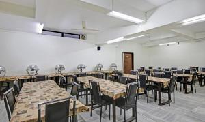 una sala da pranzo con tavoli e sedie di Treebo Trend Amexx Golf Course Road a Gurgaon