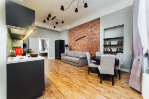 a kitchen and living room with a brick wall at Sherlock Apartments in Riga