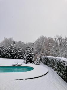 a swimming pool covered in snow next to a fence at Au cœur de l'Ardenne Bleue - Studio avec piscine in Baelen