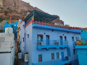 un edificio azul con balcón en un acantilado en Bhavyam Heritage Guest House, en Jodhpur