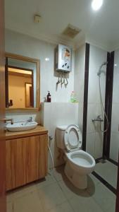 bagno con servizi igienici, lavandino e specchio di Mushroom Apartment Grand Kamala Lagoon by Mrs Sewa a Pekayon Satu