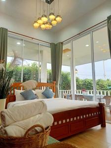 a bedroom with a large bed and large windows at ภูฝ้ายวิลล่า Phufai villa in Chiang Khan