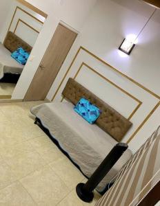 Un dormitorio con una cama con almohadas azules. en Casa a 650 metros Estación metro la Floresta., en Medellín