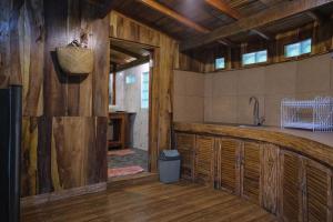 - une cuisine avec des murs en bois et un lavabo dans la chambre dans l'établissement Yeh Baat Jatiluwih by The Lavana, à Jatiluwih