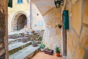 an alley with potted plants in a stone building at HelloElba Appartamento Il Borgo in Marciana