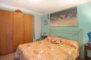 a bedroom with a bed and a painting on the wall at HelloElba Appartamento Il Borgo in Marciana