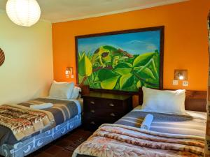 two beds in a room with a painting on the wall at Lawns Hotel in Lushoto