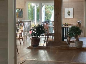 una sala de estar con sillas y una mesa con plantas. en Hotell Magasin 1, en Mörbylånga