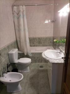 een badkamer met een toilet, een wastafel en een bad bij Flores Apartment in Porto