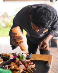 a man is preparing food on a table at Cora Cora Maldives - Premium All-Inclusive Resort in Raa Atoll