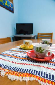 un tavolo con due tazze e piattini su una tovaglia a righe di La Quiete - Casa Vacanza a Ranzanico