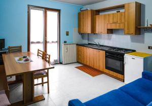 a kitchen with a table and a stove top oven at La Quiete - Casa Vacanza in Ranzanico