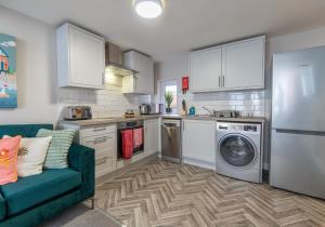 a kitchen with a refrigerator and a washing machine at Station Lodge By My Getaways in Brighton & Hove