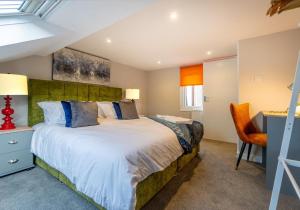 a bedroom with a large bed and a desk at Station Lodge By My Getaways in Brighton & Hove