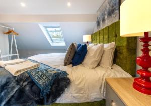 a bedroom with a white bed with a green headboard at Station Lodge By My Getaways in Brighton & Hove