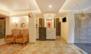 a lobby with two chairs and a glass elevator at Treebo Trend Lazystay Elite in Bhubaneshwar