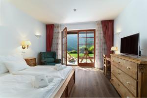 スピンドレルフ・ムリンにあるPension Slunečnice & Panorama Restaurant Farmaのベッドルーム(ベッド2台、テレビ、バルコニー付)