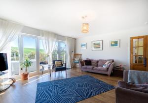 a living room with a couch and a rug at Sussex Retreat with Free Parking for 4 Vehicles - By My Getaways in Pyecombe