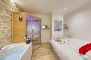 a bedroom with a bed and a bath tub at Le Petit Paris - Cocon & Spa & Sauna in Chartres