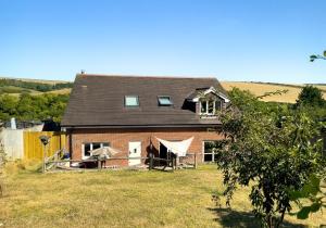 a large brick house in the middle of a field at Sussex Retreat with Free Parking for 4 Vehicles - By My Getaways in Pyecombe