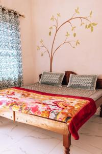 a bed in a room with a tree on the wall at Cocoon Auberge in Jaipur