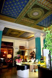 a lobby with a blue and gold ceiling and a table at Hotel Principe in Salsomaggiore Terme