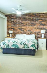 a bed in a room with a brick wall at The Gums Anchorage in Bellara