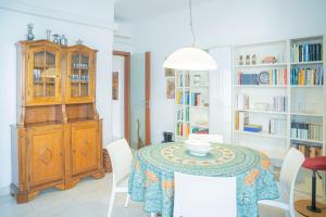 uma sala de jantar com mesa, cadeiras e estantes em 076 - Casa La Libreria, Centro città di Chiavari, 500 metri da mare e spiagge - 2 CAMERE DA LETTO em Chiavari