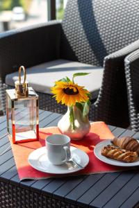 - une table avec une tasse de café et un vase avec un tournesol dans l'établissement Nowa Grochowska Apartments by Renters, à Varsovie