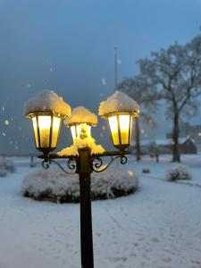 una luz de la calle cubierta de nieve con dos luces en Hotell Magasin 1, en Mörbylånga