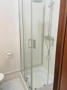 a shower with a glass door in a bathroom at Jardim do Carregal in Porto