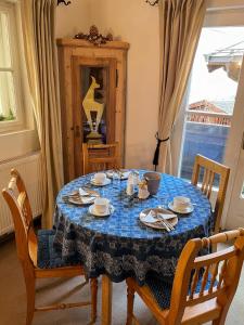 einen Esstisch mit einem blauen Tischtuch darauf in der Unterkunft Koller, Pension Haus in Kitzbühel