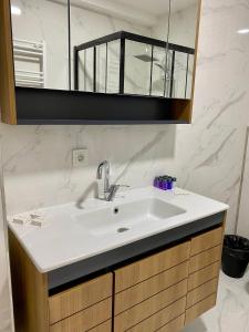 ein Badezimmer mit einem weißen Waschbecken und einem Spiegel in der Unterkunft New Apartment by MSuites in Kadikoy 01 in Istanbul