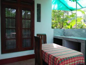 una sala da pranzo con tavolo e lavandino di Ananda Villa Bentota a Bentota