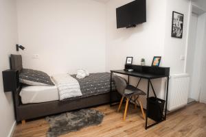 a bedroom with a bed with a desk and a television at LaRoom in Zagreb