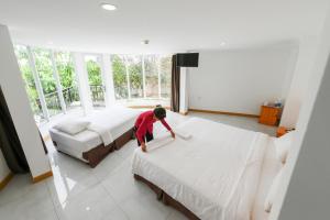 a boy making a bed in a bedroom at KDL Làng Nổi Tân Lập - Tan Lap Floating Village in Mộc Hóa