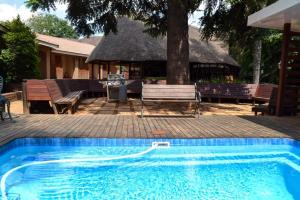 a blue swimming pool with a gazebo and a house at Goodnight Guest Lodge in Johannesburg
