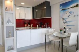 a kitchen with white cabinets and a table and chairs at Calpemar Vistas panorámicas a la playa 4º piso in Calpe